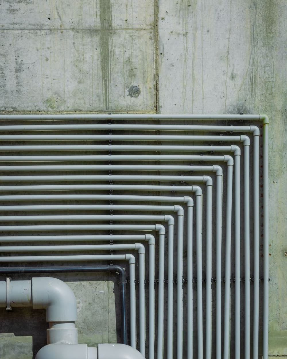 Tubería de PVC gris instalada sobre muro de concreto